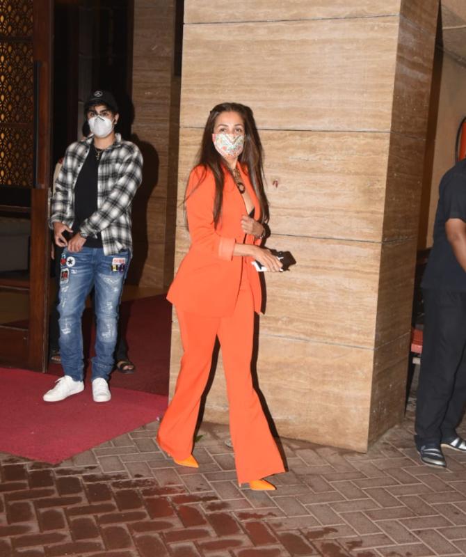 Malaika stunned the paparazzi (like always) in her bright orange pantsuit and colourful mask, while Arhaan looked dapper in his plaid black and white shirt and blue jeans, which he paired with a black cap.