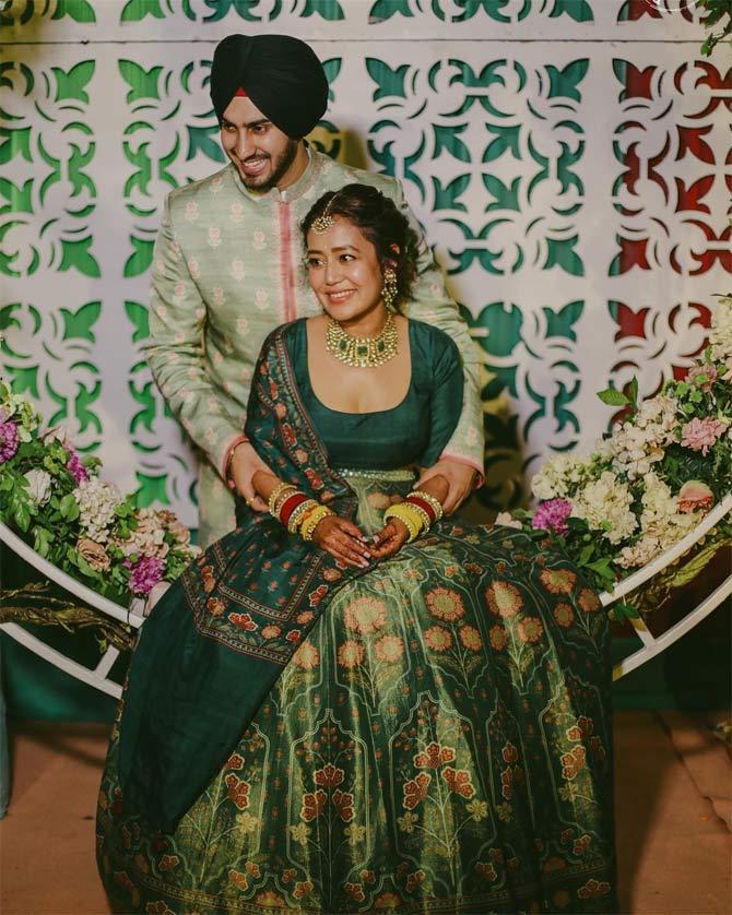 In the pictures shared by Neha Kakkar on her Instagram handle, we can see the couple enjoying the Mehendi rituals to the fullest. The 32-year-old singer can be seen glowing with happiness in her bottle green lehenga by Anita Dongre, while her soon-to-be-husband matched her style in a green sherwani.