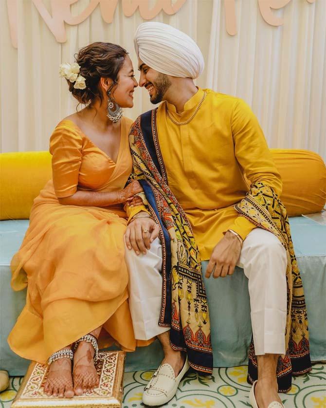 Neha Kakkar opted for a plain yellow saree for the Haldi ceremony, whereas Rohan showed off his dapper side in a yellow kurta, paired with white pants and a shawl. Paired with silver jewellery, Neha had a completely new take on Haldi outfits.