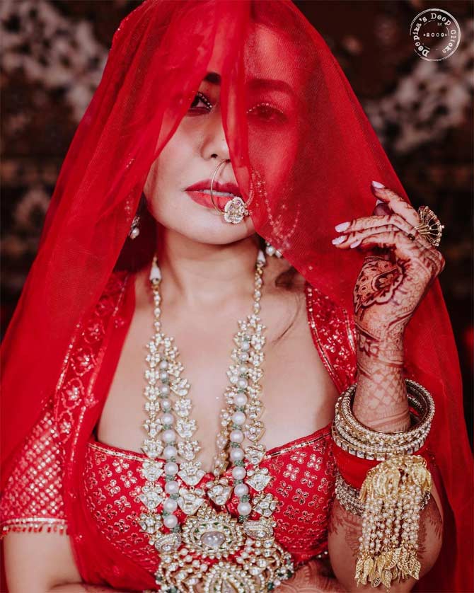 Neha Kakkar's red lehenga with gota work added an extra oomph to her reception outfit. The singer looked no less than a diva. She paired her ensemble with Kundan jewellery. Her dramatic eye makeup highlighted her sultry avatar!
