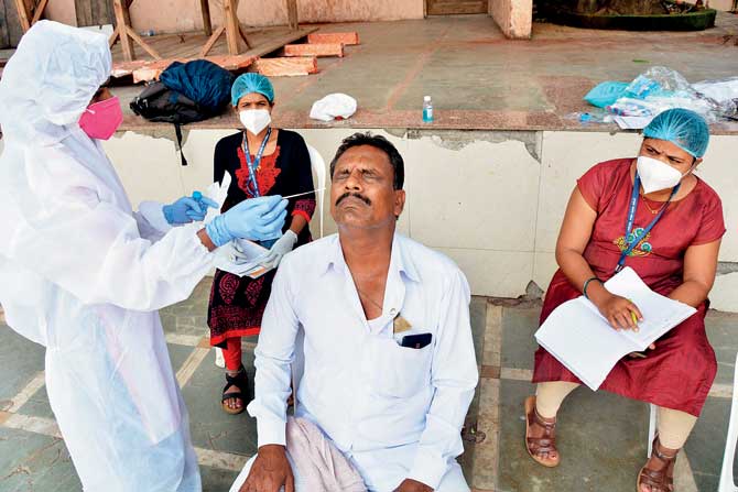 A civic medic collects samples for COVID-19 test at Sarveswar mandir, Takiya ward. 