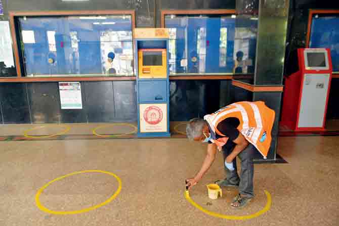 A railway staffer draws social distancing markings at Borivl railway stationi.PIC/SATEJ SHINDE