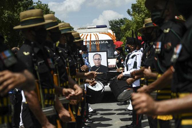 In photo: Security personnel escort an ambulance carrying the mortal remains of Pranab Mukherjee as they leave his residence for the final rites.