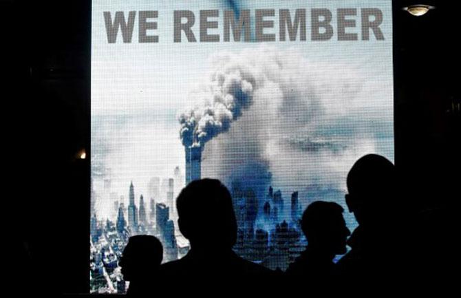 In photo: Kosovo Albanians stand in front of a screen reading 'We Remember' displayed outside the national theater in Pristina on September 11, 2018, during a commemoration ceremony on the anniversary of the September 11, 2001 attacks of the World Trade Center, in New York.