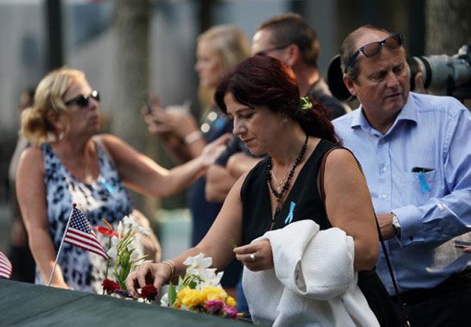 In photo: People leave flowers during the September 11 Commemoration Ceremony at the 9/11 Memorial at the World Trade Center on September 11, 2019, in New York.