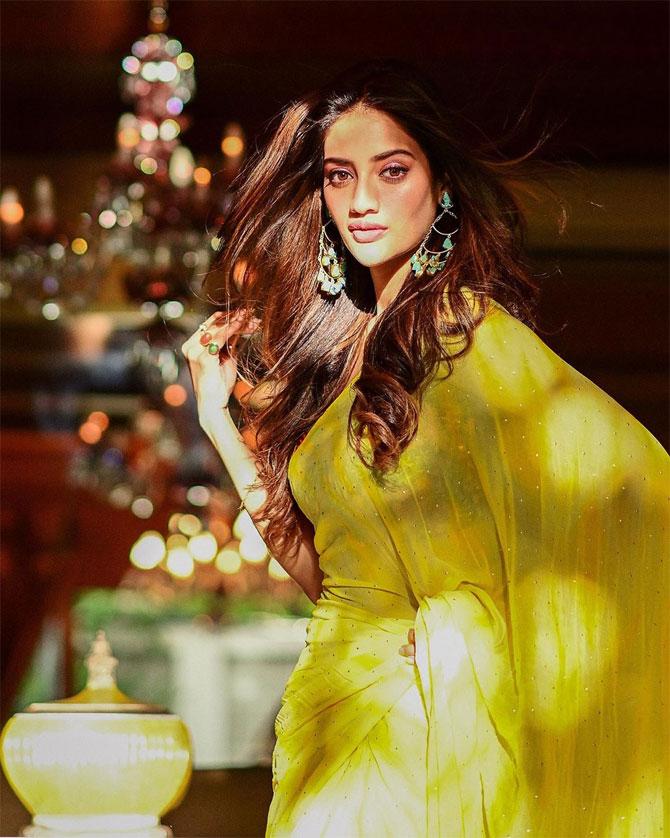The Trinamool Congress MP shared this candid picture from one of her photoshoots after the lockdown was lifted. In this picture, Nusrat looks glamorous in a yellow saree which she paired with a sleeveless blouse. Nusrat completed her look with subtle makeup and left her beautiful long tresses open.