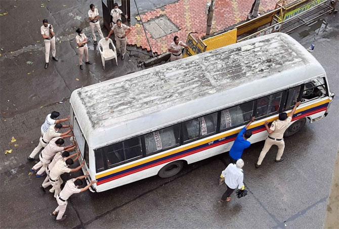 In picture: Mumbai Police personnel push their vehicle as it broke down outside Borivli railway station.
