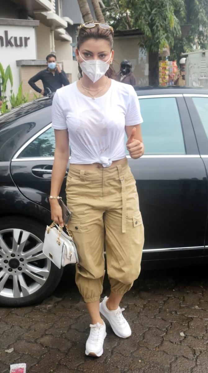 Urvashi Rautela seemed all happy and cheerful when clicked by the photographers in Juhu, Mumbai. The actress looked chic in her white crop top and beige coloured trousers. She wore a pair of white shoes and carried a white handbag to complete her look. To prevent the spread of COVID-19 she opted for a white mask. (All pictures: Yogen Shah).