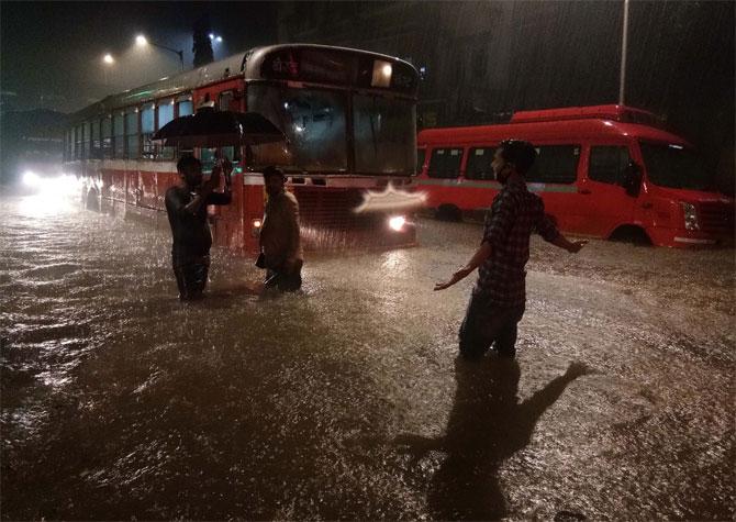 In picture: People enjoy the sudden spell of showers, while BEST buses are stranded due to waterlogging at Dadar TT.