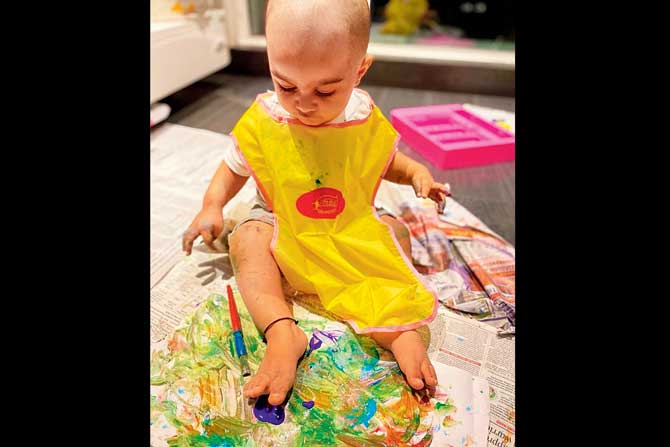 Ivaan Mehta seen here finger painting, but it’s flash cards say his parents, that have caught his fancy