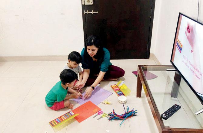 Rashmi Hemrajani watching a DIY video with her twins Ryan and Ethan