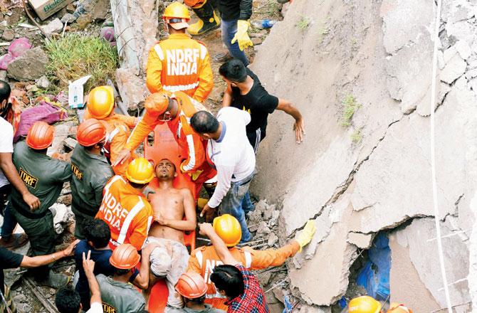 NDRF personnel rescue survivors from the site