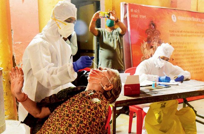 Health workers collect swab samples for rapid antigen tests at Samaj Mandir hall, Mahim West on Wednesday. Pic/Suresh Karkera