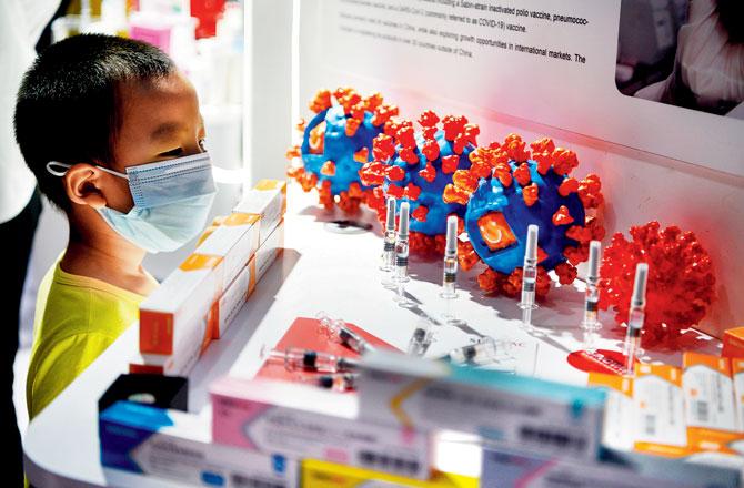 A boy looks at the COVID-19 vaccine candidate on display at the China International Fair for Trade in Services in Beijing on Sunday. China has put its home-grown coronavirus vaccine candidates, produced by Chinese firms Sinovac Biotech and Sinopharm, on display. Neither has hit the market yet but the makers hope they will be approved after all-important phase 3 trials as early as year-end. Pic/AFP