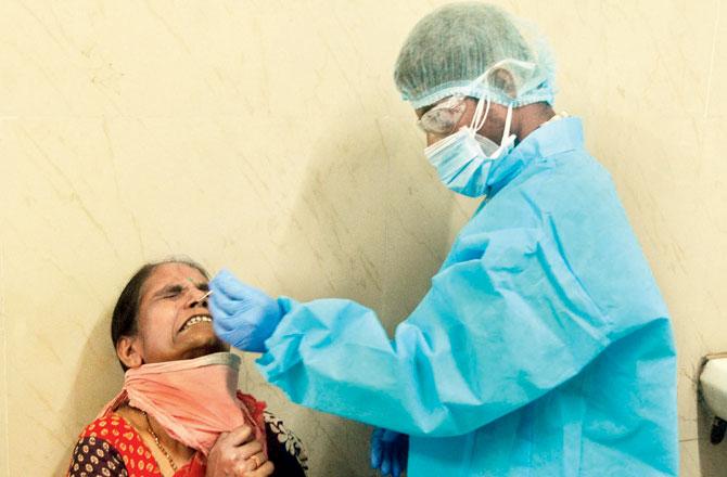 A health worker collects swab samples of a woman. Pic/Sayyed Sameer Abedi  