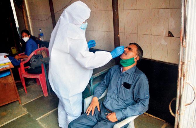 A BMC health worker tests a resident in Kurla. Pic/Sayyed Sameer Abedi