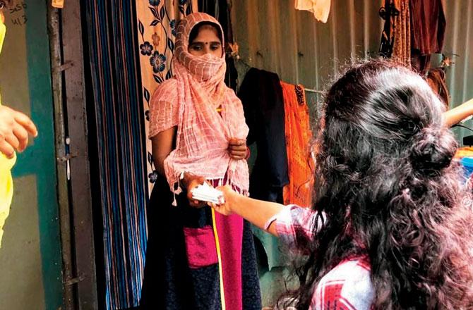 A volunteer hands a sanitary pad