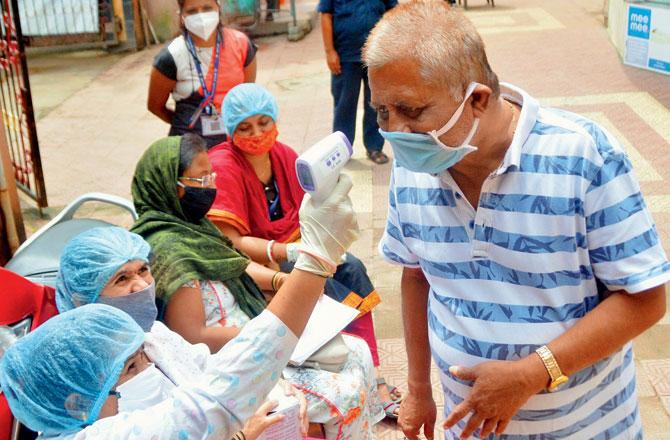 Civic doctors and health workers screen residents of Manshi Apartment for COVID-19 symptoms in Kurla, on Tuesday