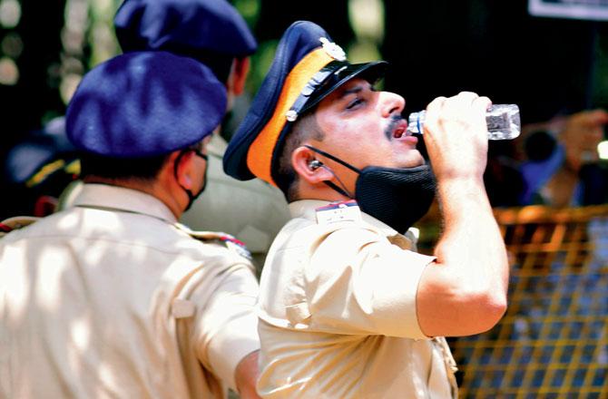 A police officer quenches his thirst in Bandra. Pic/Pradeep Dhivar