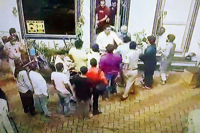A cop (third from right) is seen in a CCTV grab of the incident trying to pacify the crowd. PIC/Hanif Patel