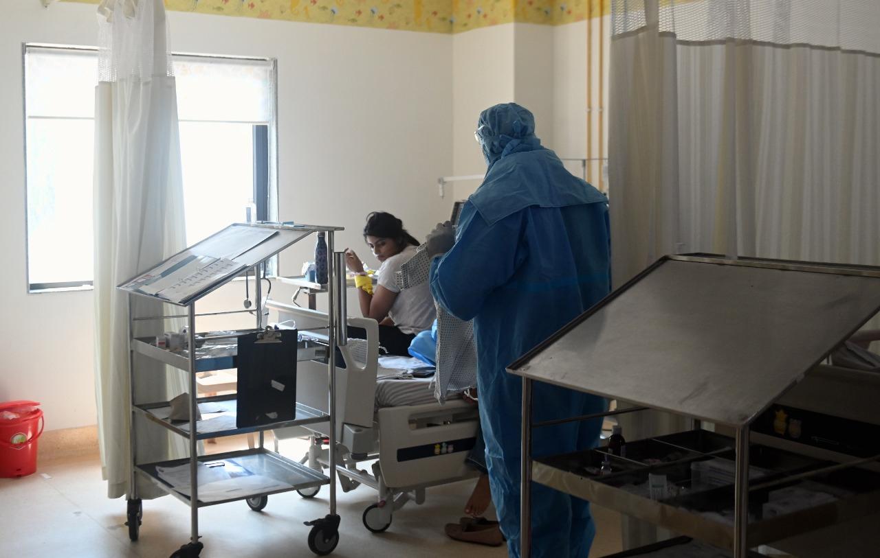 In photo: A nursing staff dressed in a  PPE suit tries to teach and encourage a COVID-19 positive child admitted to the kid's isolation ward of SRCC Children's Hospital.