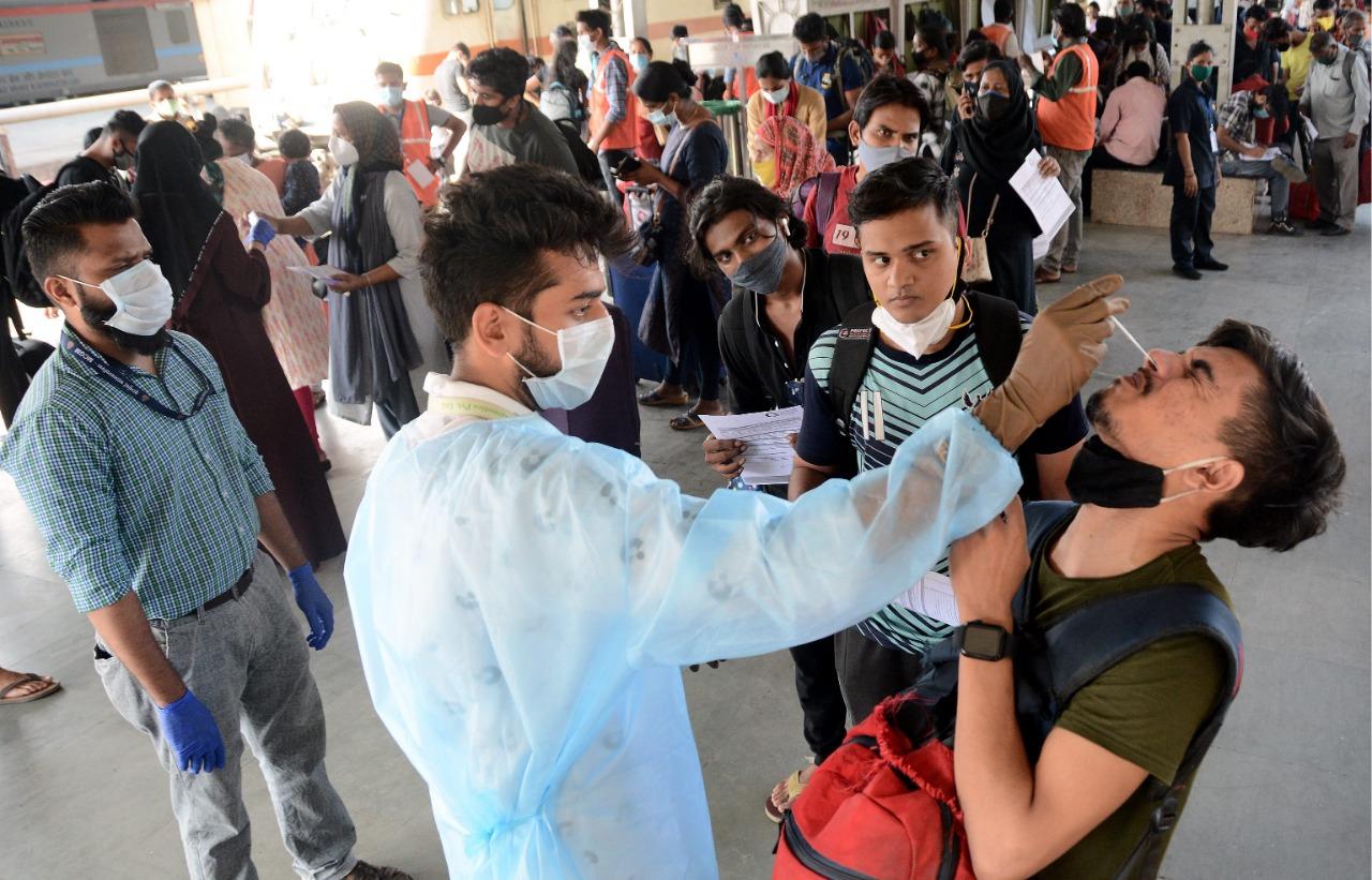A BMC healthcare worker collects swab samples of passengers arriving from other states to Mumbai amid the COVID-19 crisis in the city. Photo: Sameer Abedi