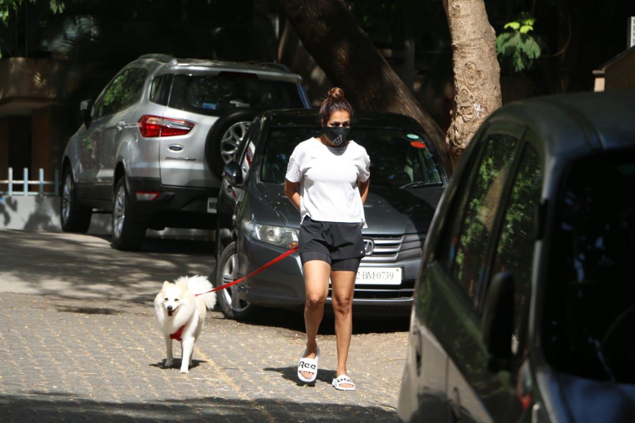 Malaika Arora stepped out with her pooch for a morning walk on the streets of Bandra, Mumbai. Like always, Malaika looked smartly dressed in a white tee, black running shorts and slip-on.