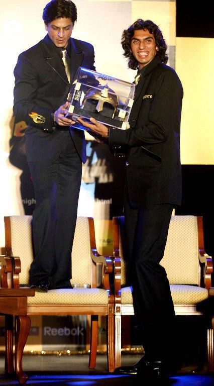SRK stands tall KKR owner Shah Rukh Khan (L) hands over a replica helmet to pace bowler Ishant Sharma during a press meet in Mumbai on March 13, 2008. Shah Rukh had to stand on a chair to hand over the helmet