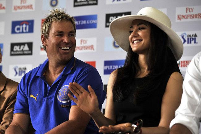 Hats off to Warnie?: Former Rajasthan Royals player, the late Shane Warne (L) and Bollywood actress and shareholder of the Punjab Kings, Preity Zinta (R) laugh as they sit on stage at the Alexander Sinton High School on April 17, 2009, in Athlone, Cape Town, South Africa.