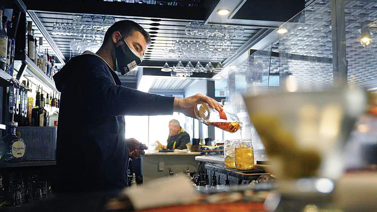 ‘Vaxxed people can carry as much virus as others’ A masked bartender pours a drink at Tin Pan Alley restaurant in Provincetown, Massachusetts. Pic/AFP