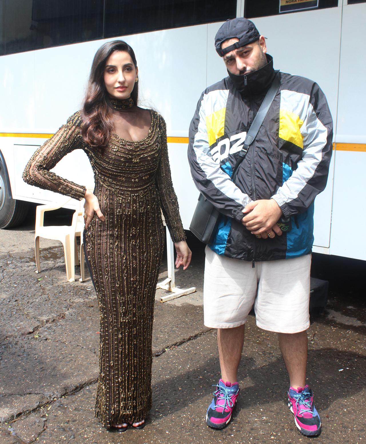 Nora Fatehi and Badshah were snapped together outside a studio in Mumbai. Buzz is that the duo may collaborate soon. Nora looked stunning in a shimmery golden gown, while Badshaah kept it stylish in a jacket and shorts.