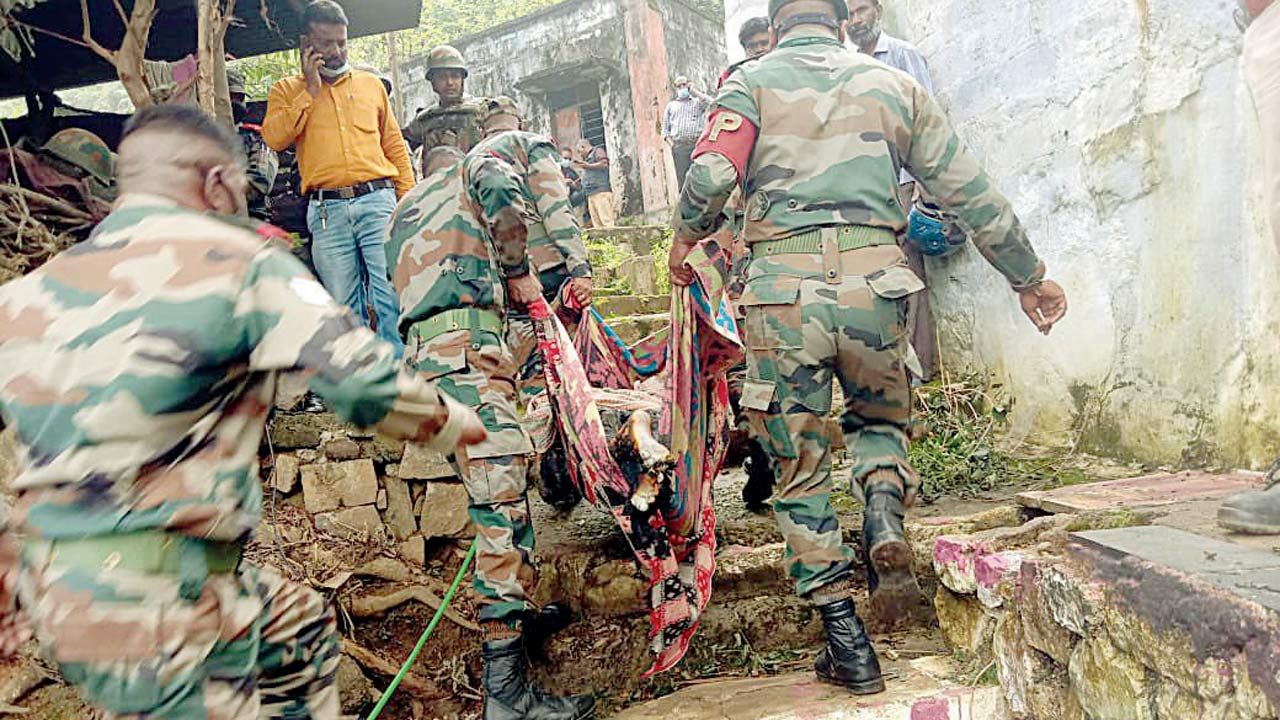 Soldiers carry a victim  through a settlement. Pics/PTI, ANI