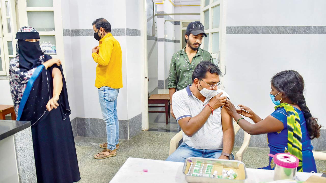 A health worker administers a dose of COVID vaccine to a man, in Bengaluru on Friday. Pic/PTI