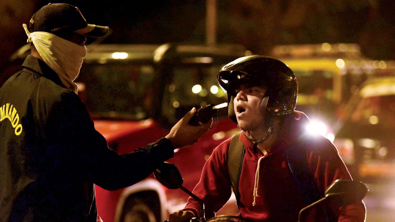 A cop uses a breathalyser on a biker on December 31, 2019. File pic