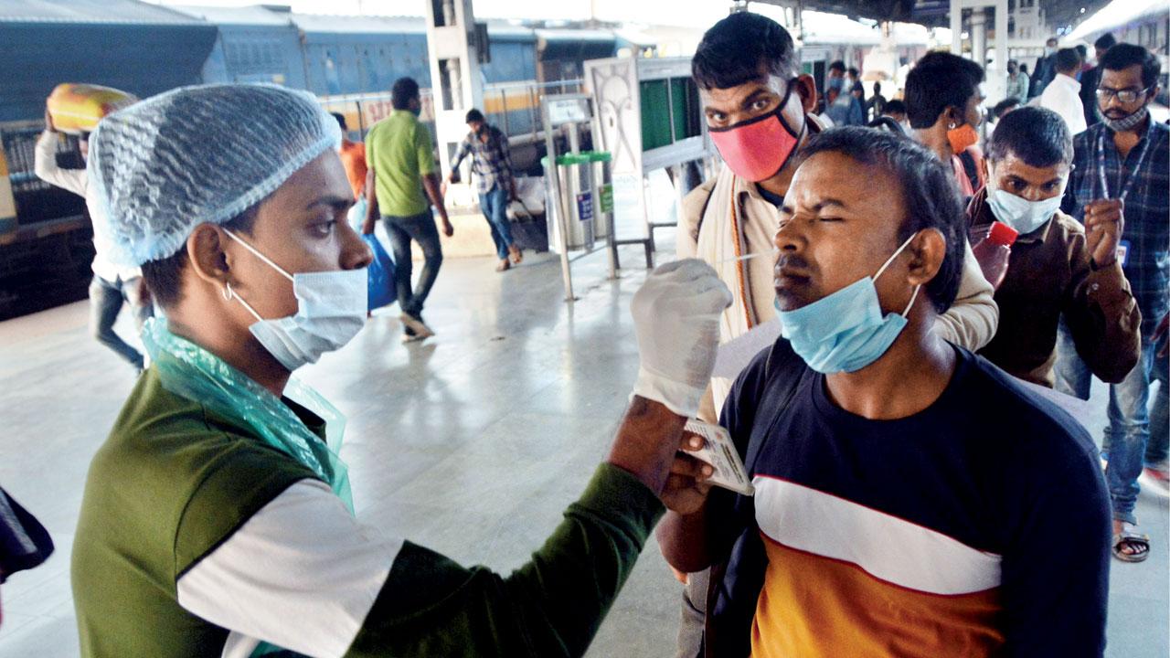 A health worker collects a swab of a train passenger at LTT, Kurla, on Friday. Pic/ Sayyed Sameer Abedi