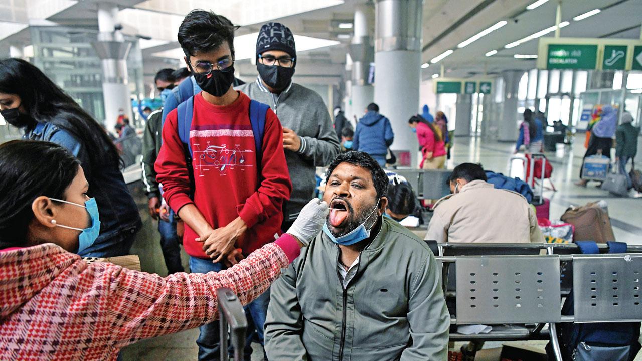 A healthcare worker collects an oral swab sample at the Interstate Bus Terminal Kashmere Gate, in New Delhi on Friday. Pic/ANI