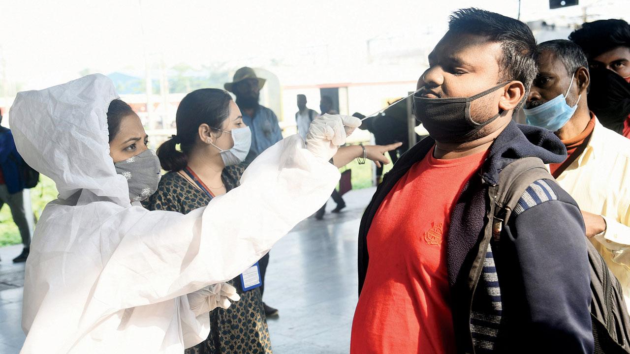 A health worker collects the swab sample of a passenger at Lokmanya Tilak Terminus, Kurla on Thursday. Pic/Sameer Markande