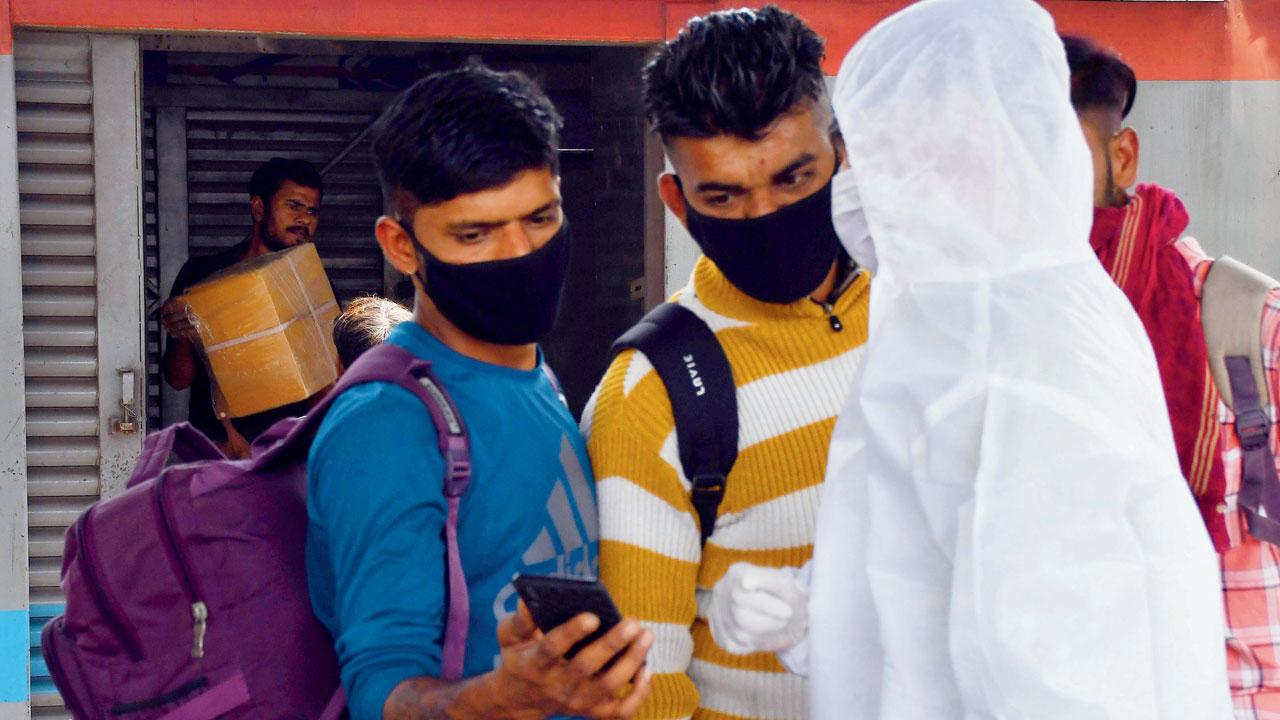 Passengers show their second dose certificate of the Covid-19 vaccination at Dadar station on Thursday. Pic/Ashish Raje