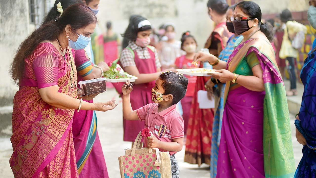 Teachers welcome students with gifts and flowers at Sadhna Vidyalaya School in Sion, on Wednesday