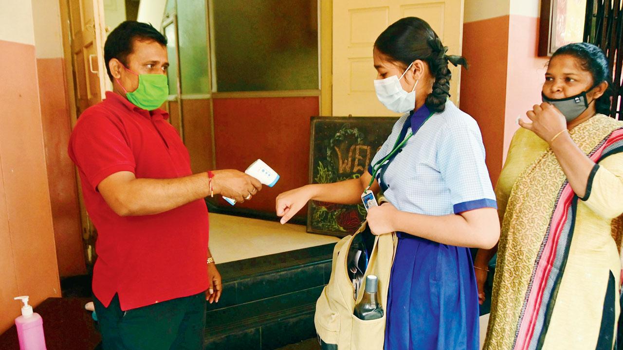 A student is screened at the entry, at a school in south Mumbai. File pic
