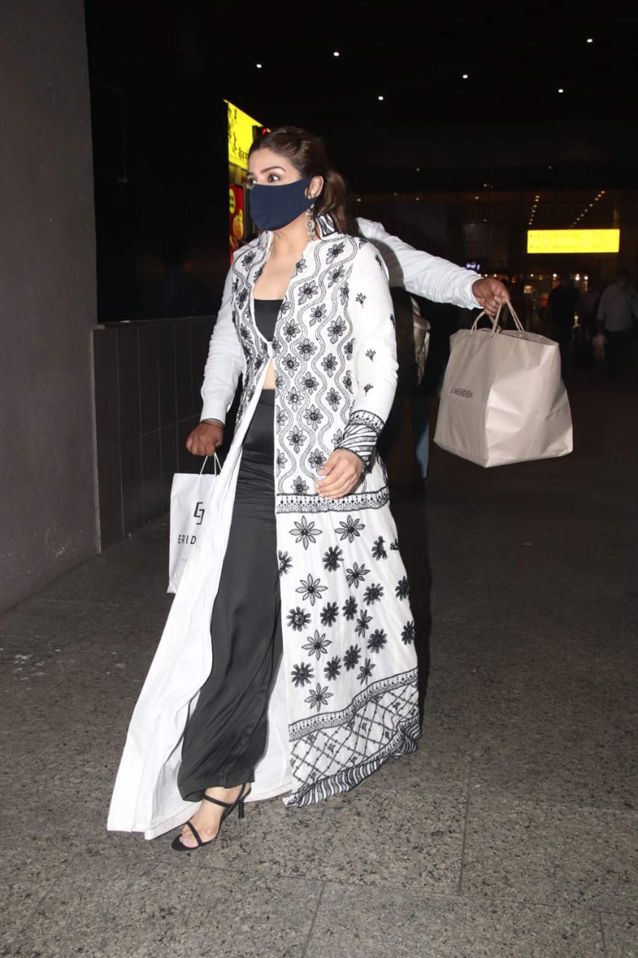 Another off guard situation was for Raveena Tandon! As the actress was walking the airport aisle, one of her staff members was snapped in a very awkward position as he was juggling with some shopping bags just behind the Mohra actress; making us think whether Raveena has got two more hands for real. Take a look at the picture right away! Another off guard situation was for Raveena Tandon! As the actress was walking the airport aisle, one of her staff members was snapped in a very awkward position as he was juggling with some shopping bags just behind the Mohra actress; making us think whether Raveena has got two more hands for real. Take a look at the picture right away!