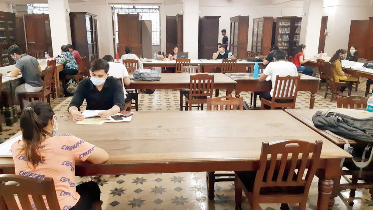 People pore over books at the library during the pandemic