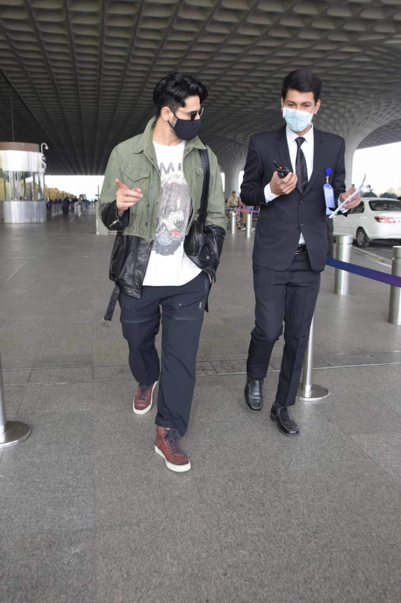 Sidharth Malhotra donned a moss green jacket, paired with a graphic tee and black chinos for the outing. The duo was all smiles when clicked by the shutterbugs at the Mumbai airport.