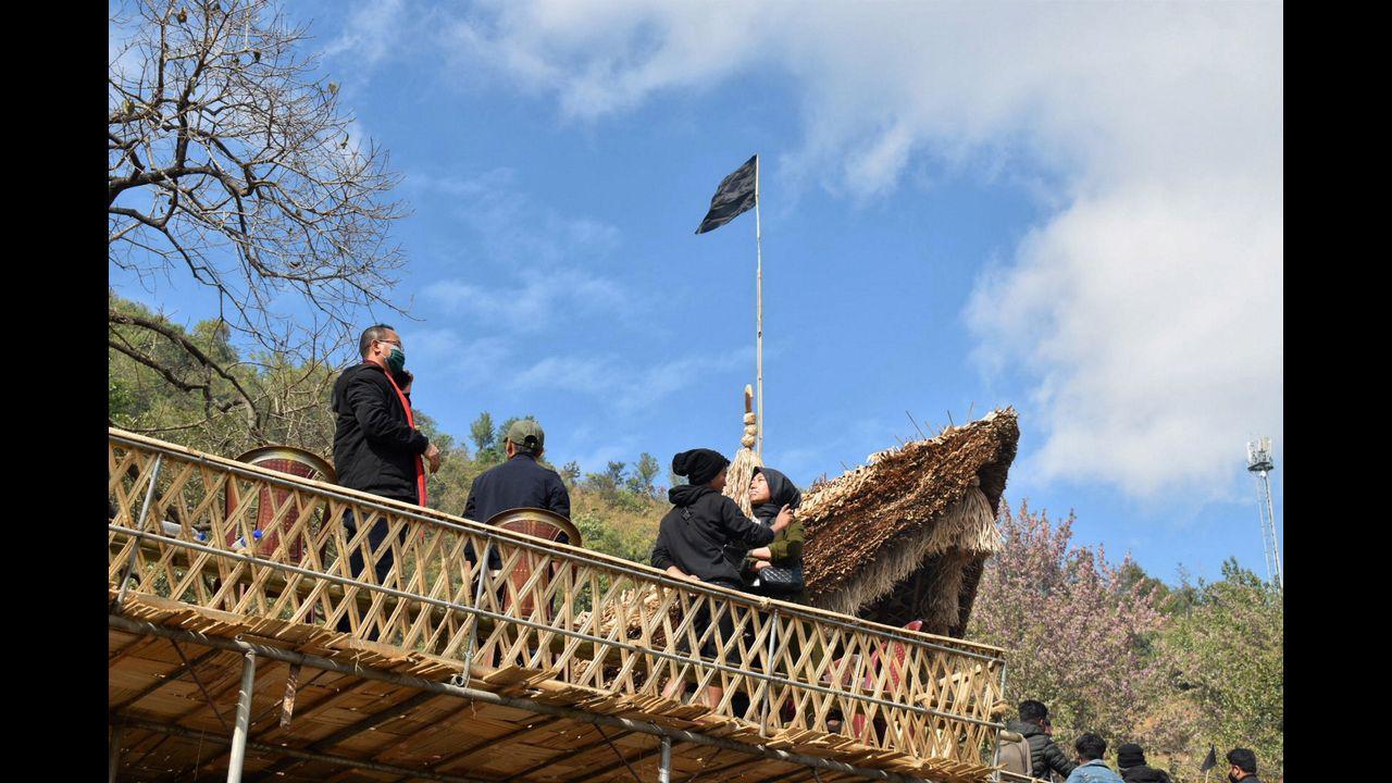 A black flag being hoisted at the venue of Hornbill festival in solidarity with the civilians, killed in an anti-insurgency operation, in Kisama, Nagaland. Pic/PTI