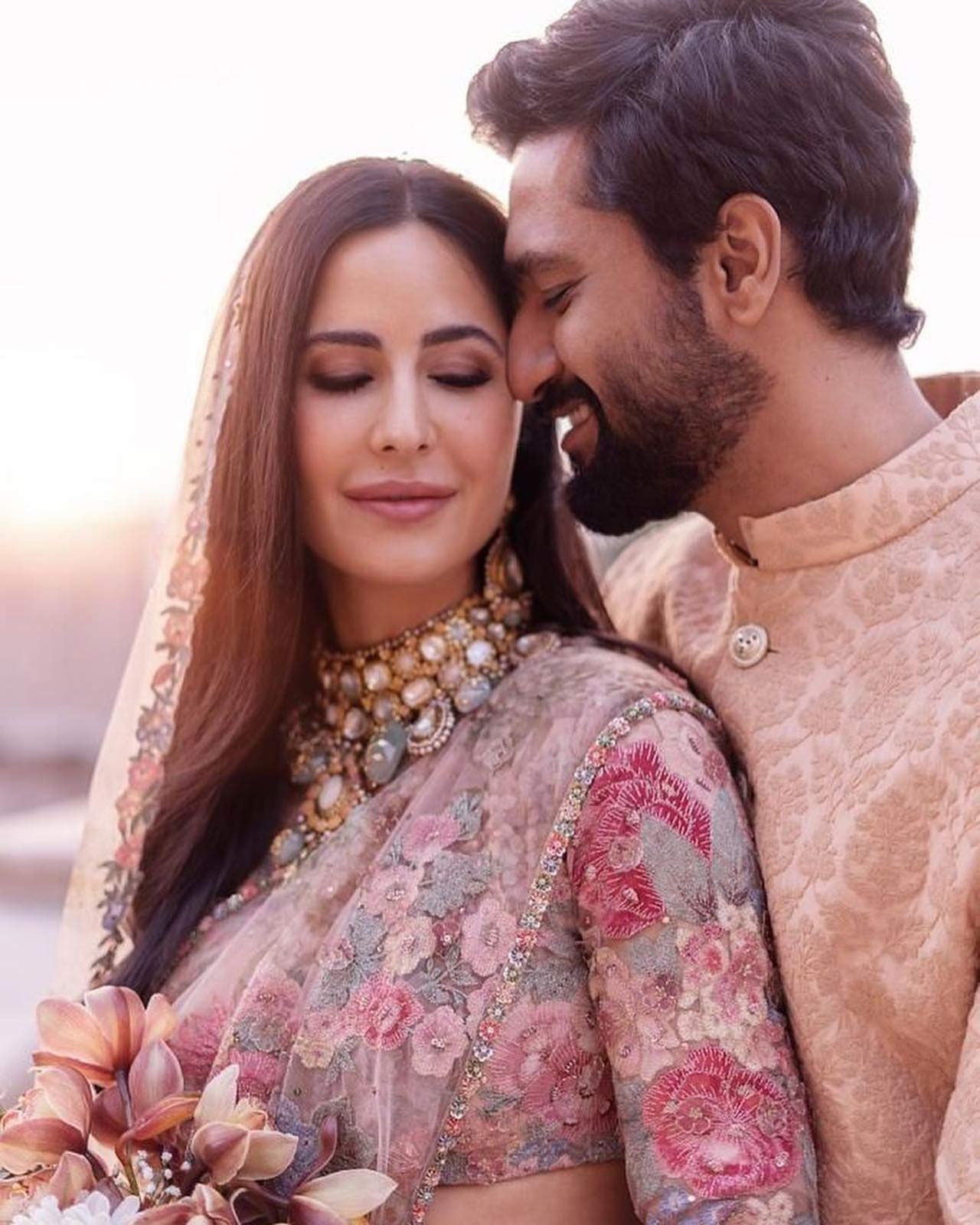 Katrina Kaif posted a new series of photos where the actress is seen wearing a dreamy saree with a veil. The look is already ruling the internet. While Kat is seen wearing a saree, Vicky dons a Nehru suit, twinning with his wife, and we can't get over it!