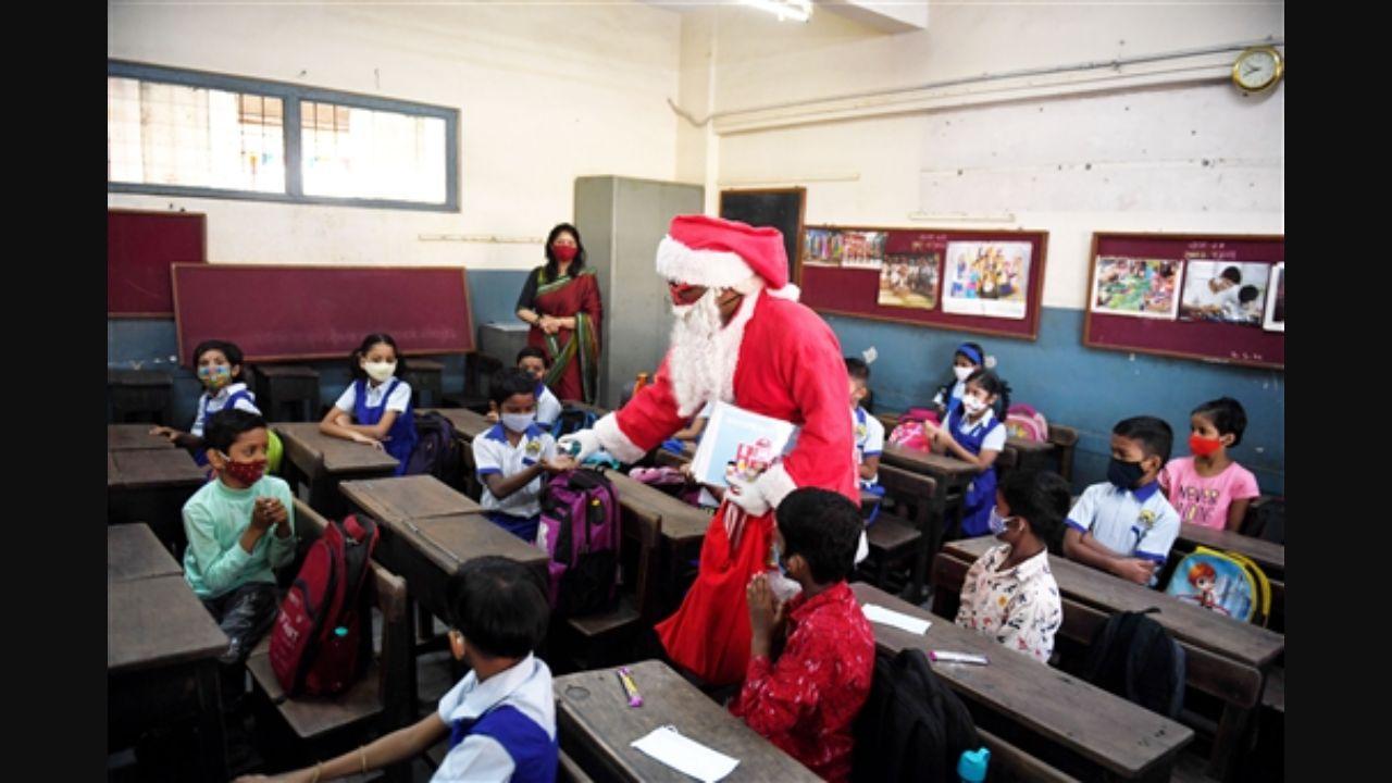 A man dressed as Santa Claus raises Covid-19 awareness after primary schools for Classes 1 to 7 reopened in Mumbai. Pic/PTI