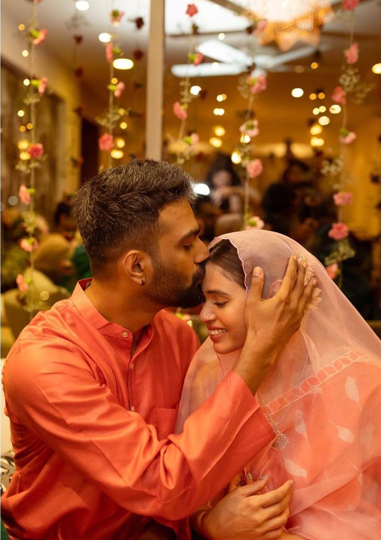 For the occasion, Shalmali and her husband twinned in orange-coloured outfits. Shalmali dressed up in an orange-beige colour printed saree with a white halter neck blouse and paired it with a set of silver jhumkas. 