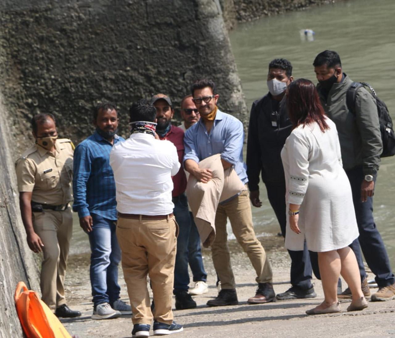 Aamir Khan obliged fans with pictures, as soon as he stepped out of the ferry. He sported a casual look - blue shirt, beige pants, leather boots, and of course wore a mask. Not to be missed, Aamir carried his pillow, that he never forgets to accompany him on his journeys.