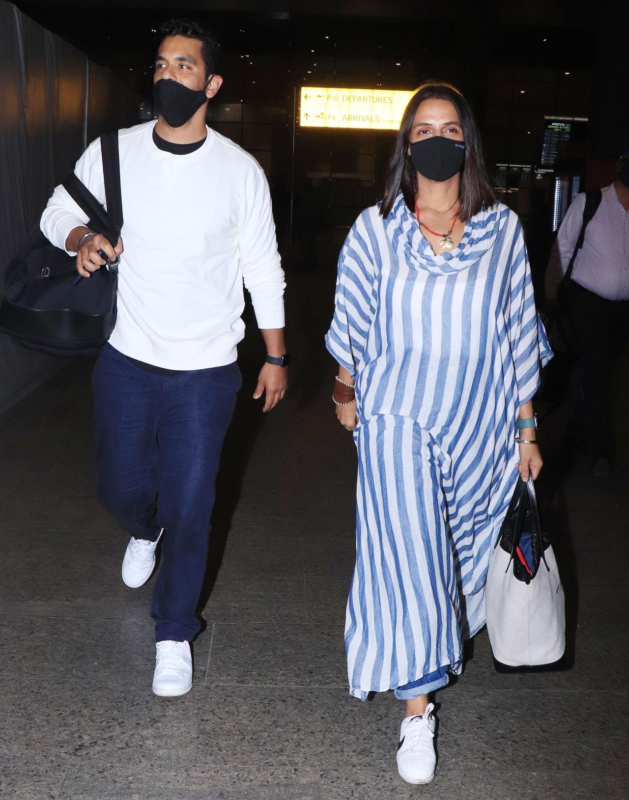 Neha Dhupia and Angad Bedi were clicked at the Mumbai airport. While Angad kept it casual in a white tee and denim, Neha wore a kaftan top and denim as they arrived at the airport.