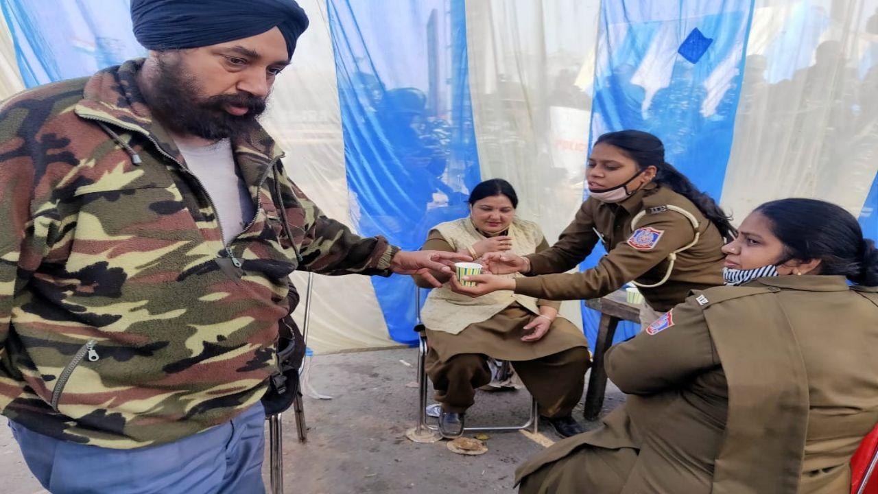 A protester gives tea to a policewoman in New Delhi. Pic/Diwakar Sharma